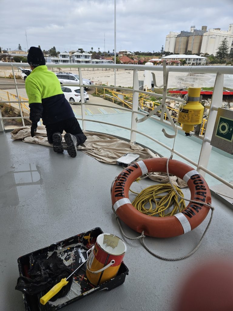 Contractor painting upper deck of Aurora V.